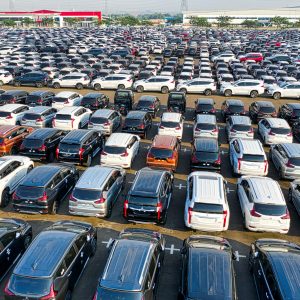 From above of rows with many modern new shiny automobiles of contemporary industry in daytime